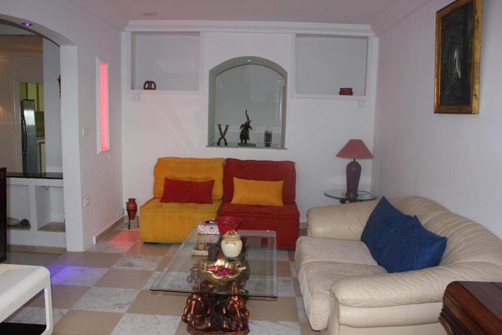 a living room with two couches and a table at Appartement Alain savary in Tunis