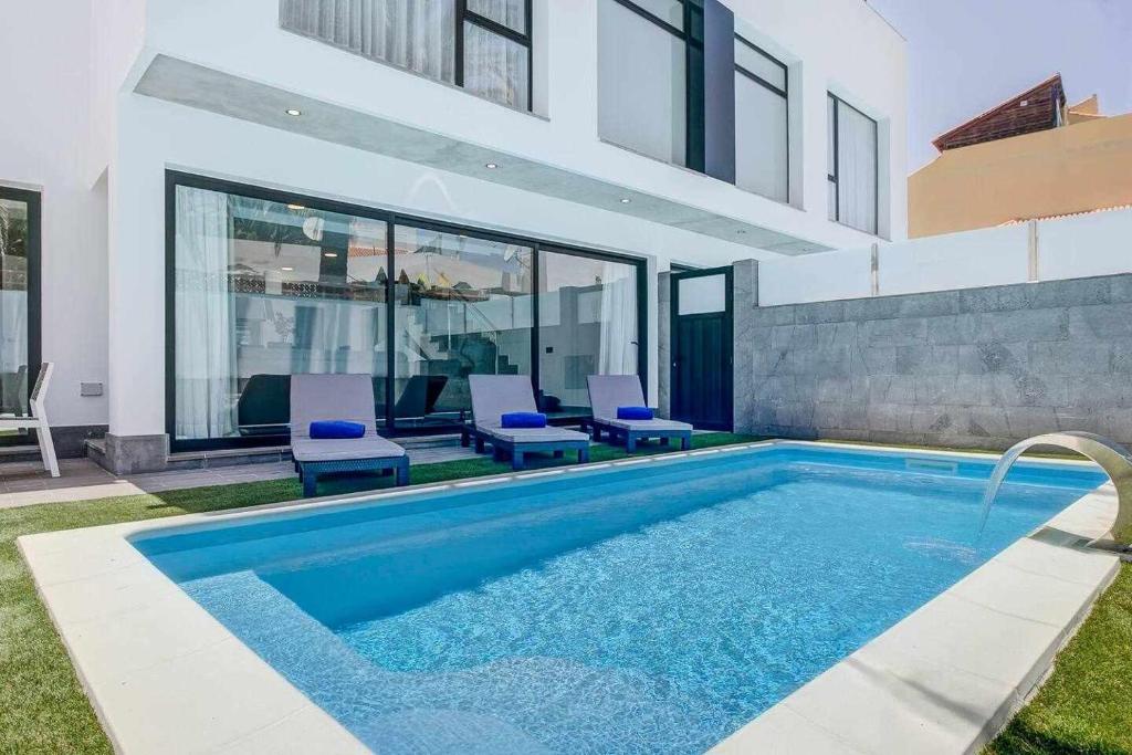 a swimming pool in the backyard of a house at Two Dreams Luxury Villa in Corralejo