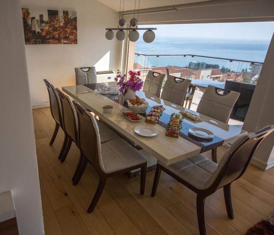 a dining room table and chairs with a view of the ocean at Spa Resort Luxury Apartments in Budva