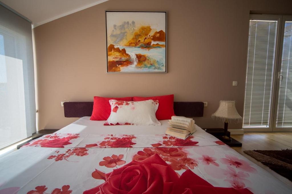a bedroom with a large bed with red flowers on it at Spa Resort Luxury Apartments in Budva