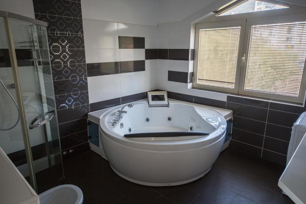 a bathroom with a large tub and a shower at Spa Resort Luxury Apartments in Budva