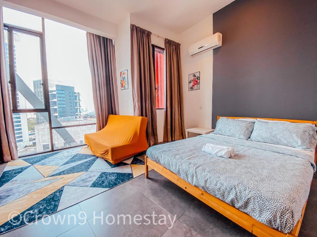 ein Schlafzimmer mit einem Bett, einem Stuhl und einem Fenster in der Unterkunft Crown2 Suite (City View)@Petaling Jaya in Petaling Jaya