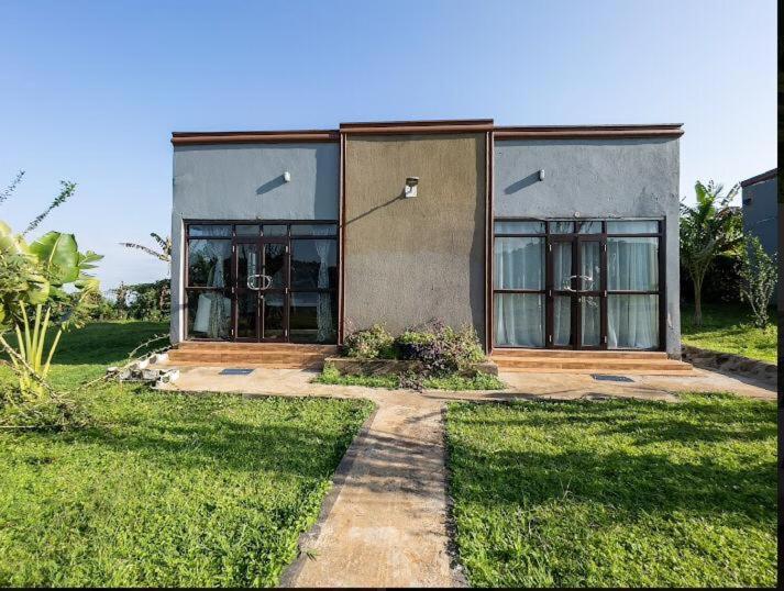 una casa con un patio de hierba delante de ella en Sipi Valley Resort, en Mbale