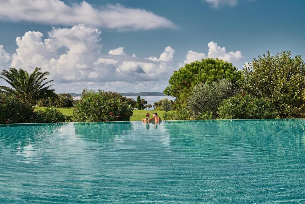 dwoje osób stojących w basenie w obiekcie Falkensteiner Hotel & Spa Iadera w mieście Zadar