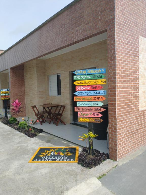 a building with a bunch of signs on the side of it at Villagio Aloha Beach in Bertioga