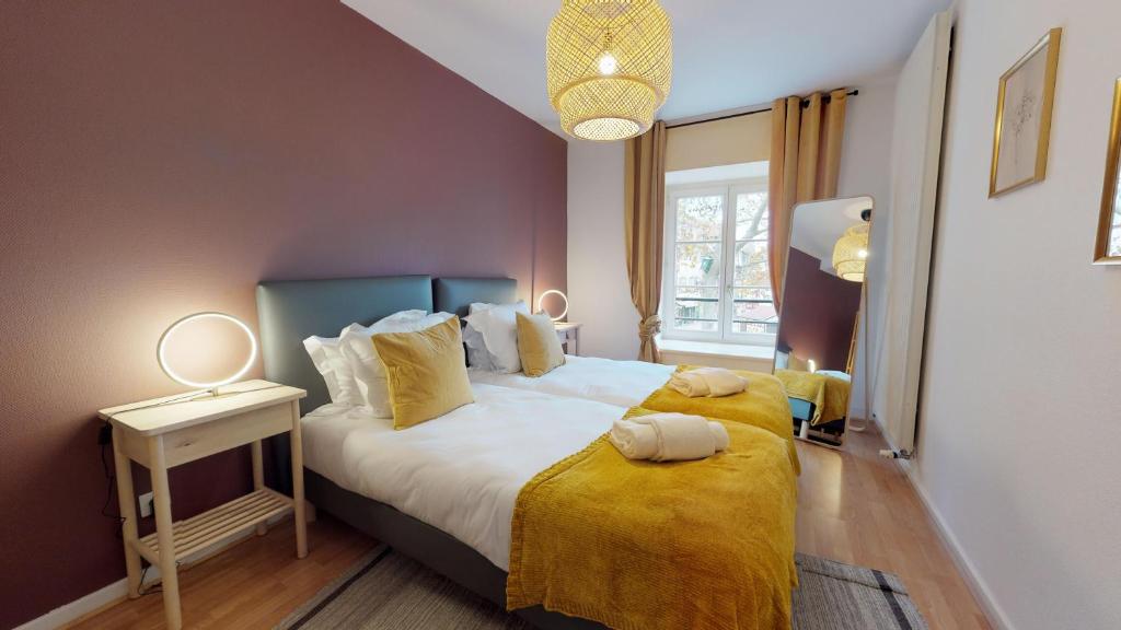 een slaapkamer met een bed met een gele deken bij IMMER 4 chambres 10 personnes in Colmar