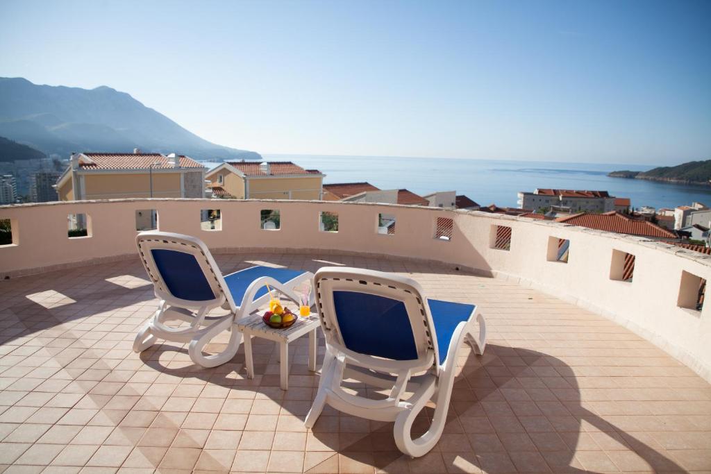 two chairs and a table on a balcony with the ocean at Spa Resort Luxury Apartments in Budva