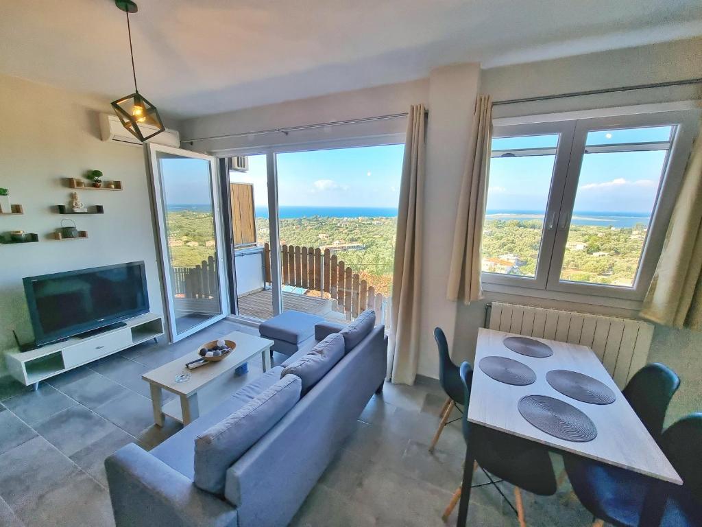 uma sala de estar com um sofá, uma mesa e uma televisão em Labros Sea View em Lefkada