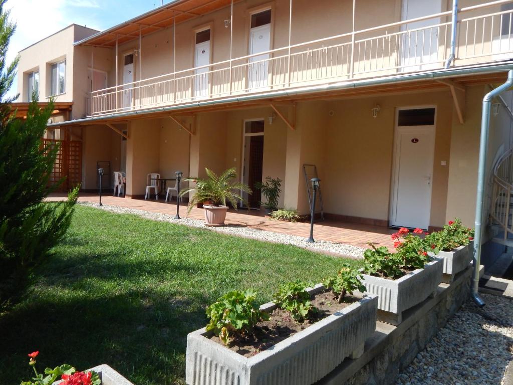 un edificio con plantas frente a un patio en Ágnes Vendégház, en Hajdúszoboszló