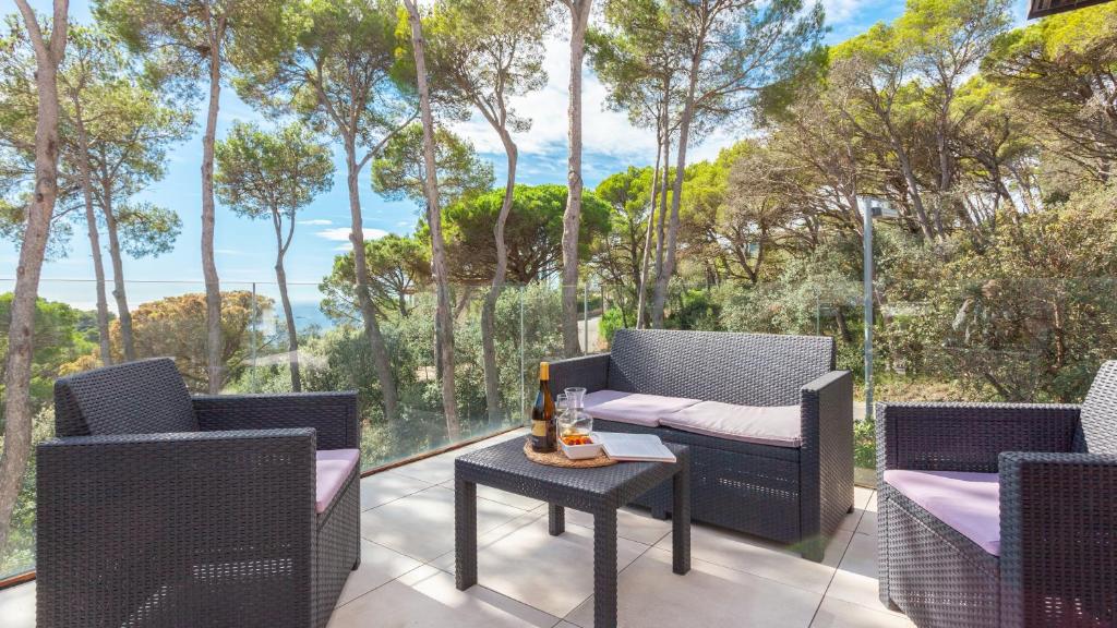 a patio with two chairs and a table and trees at VILLA MEXIC in Llafranc