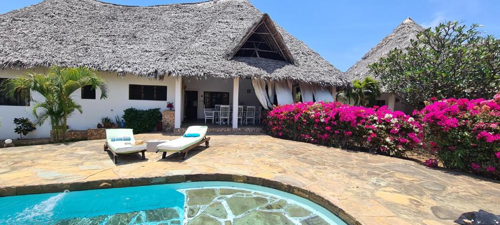 a villa with a swimming pool and a house at Lion Garden Villas in Malindi