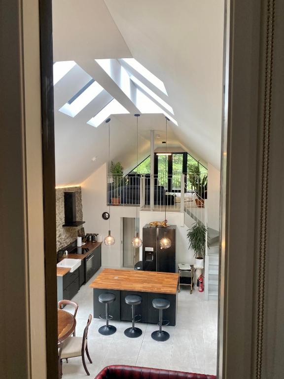 a kitchen and living room with a table and stools at The Old Bushmills Barn in Bushmills