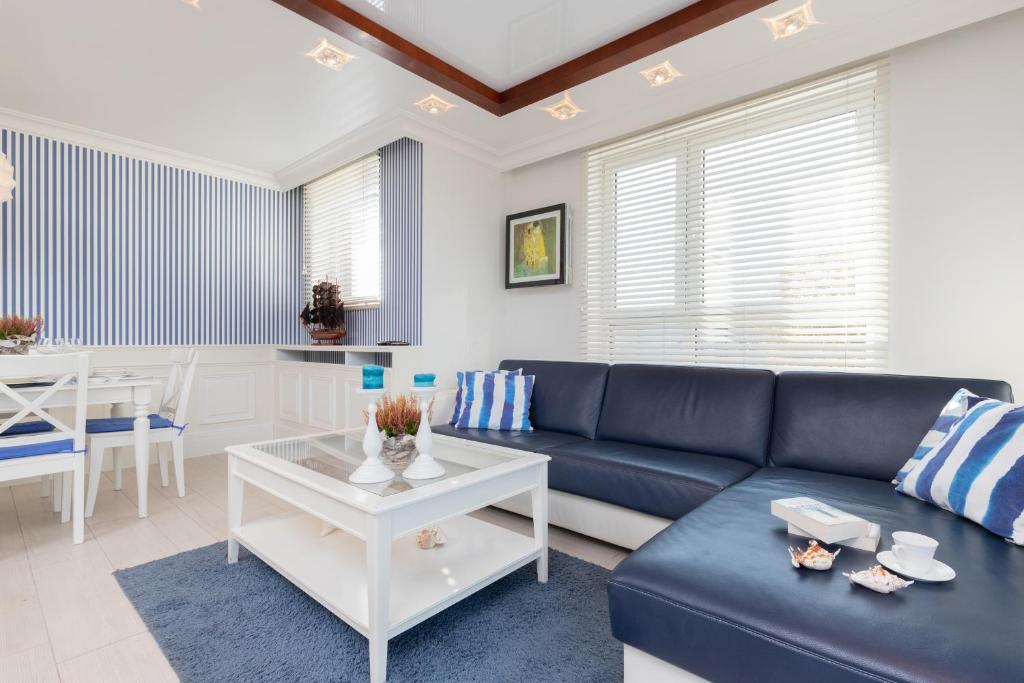 salon z niebieską kanapą i stołem w obiekcie Sailor Apartment Jastrzębia Góra by Renters Prestige w Jastrzębiej Górze