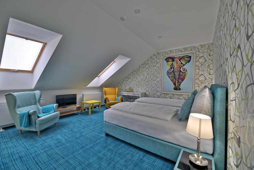 a bedroom with a bed and a chair and a television at Hotel Pod Bránou in Bardejov