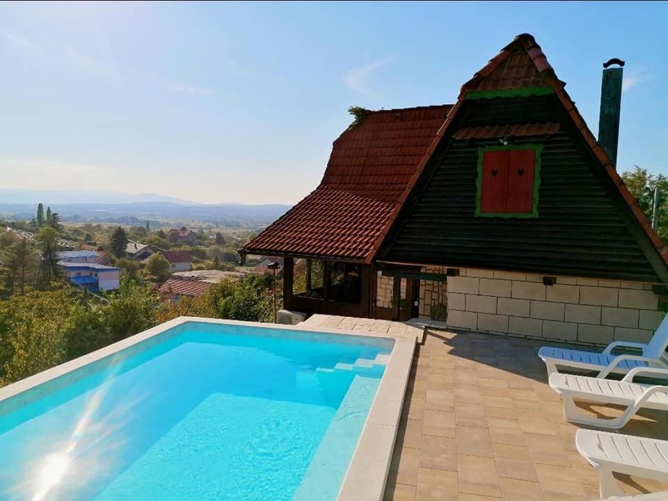 a villa with a pool and a house at Challet Bella in Poljanica Bistranska