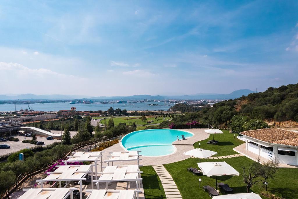 Blick auf einen Pool mit Sonnenschirmen in der Unterkunft Hotel dP Olbia - Sardinia in Olbia