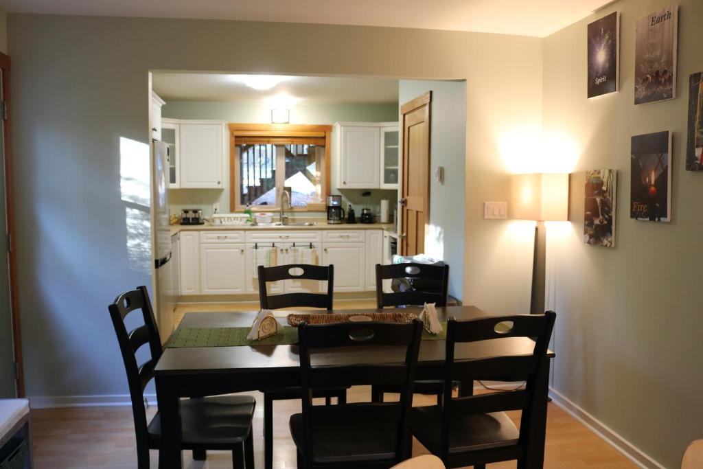 a dining room and kitchen with a table and chairs at Five Elements Lodge B&B with Outdoor Spa in Fernwood
