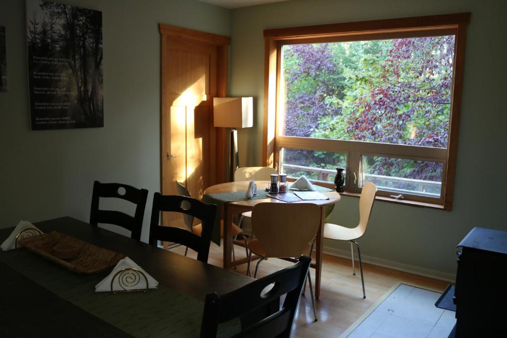 a dining room with a table and chairs and a window at Five Elements Lodge B&B with Outdoor Spa in Fernwood