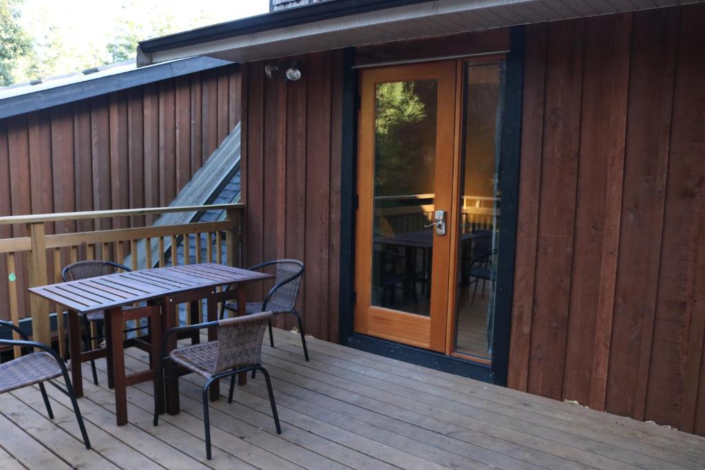 a patio with a table and chairs on a deck at Five Elements Lodge B&B with Outdoor Spa in Fernwood