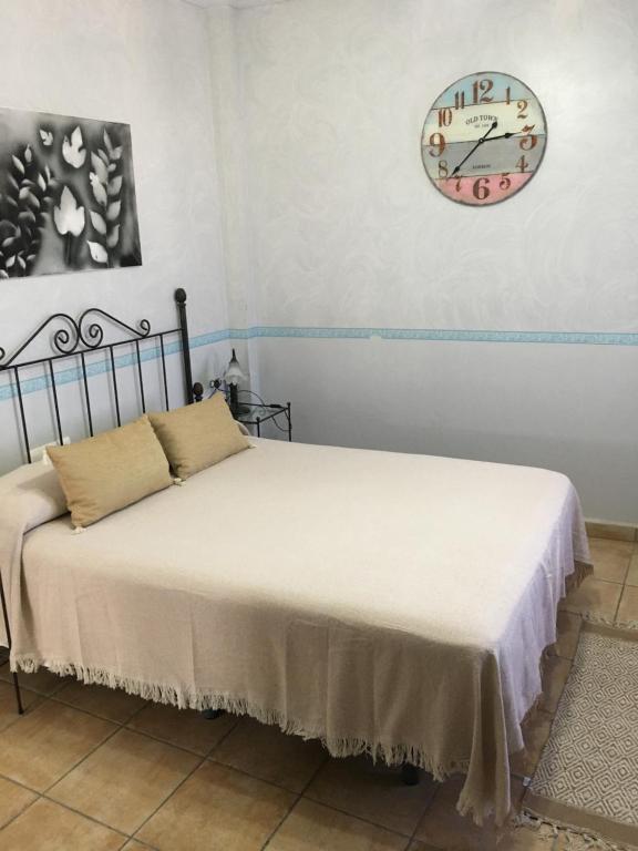 1 dormitorio con 2 camas y reloj en la pared en Venta de Abajo, en El Castillo de las Guardas