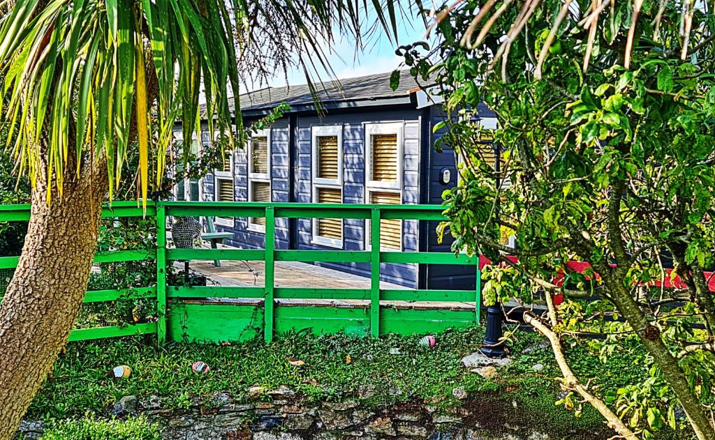 una valla verde frente a una casa en Palm Cottage en Redruth