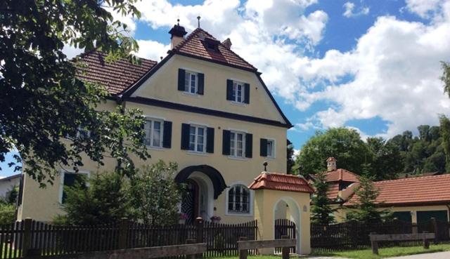 a large white house with a fence in front of it at Ferienwohnung Rosenlehner in Kiefersfelden