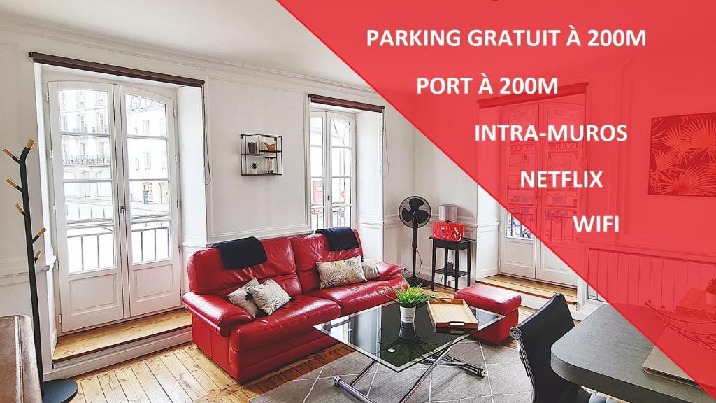 un salon avec un canapé rouge et une table dans l'établissement LES LICES, T2 de caractère en plein centre historique, à Vannes