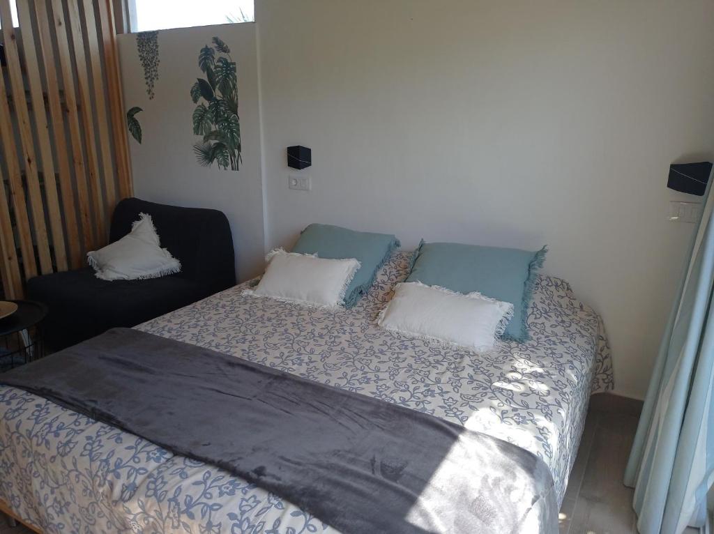 una camera con letto, 2 cuscini e una sedia di Mar&dunas a La Oliva