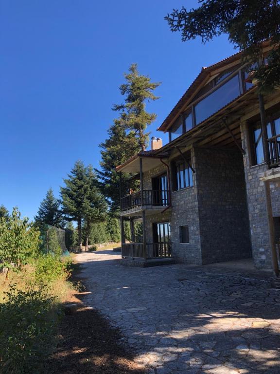 uma grande casa de pedra com um alpendre e uma varanda em Villazia The Highest em Kardharás