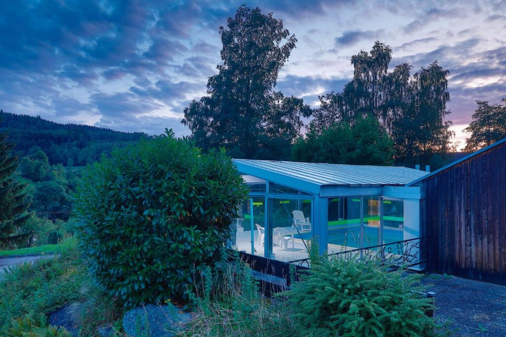 een glazen huis met een blauw dak op een heuvel bij Village Vacances Le Mongade (by Popinns) in Plainfaing