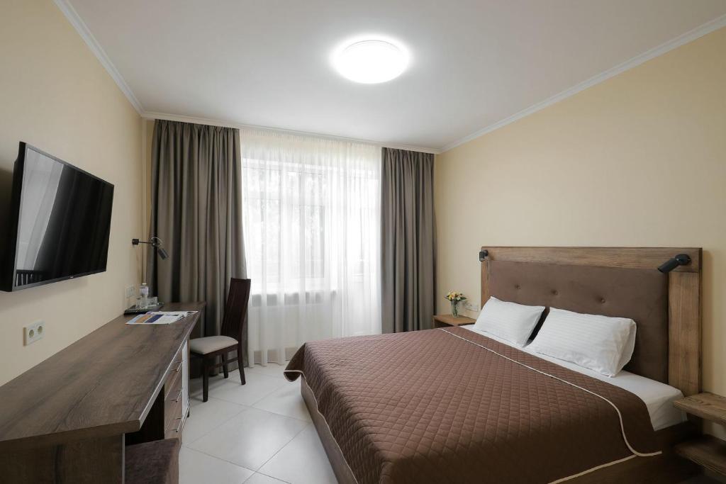 um quarto de hotel com uma cama e uma televisão em Borys Hotel Boryspil Airport em Boryspil