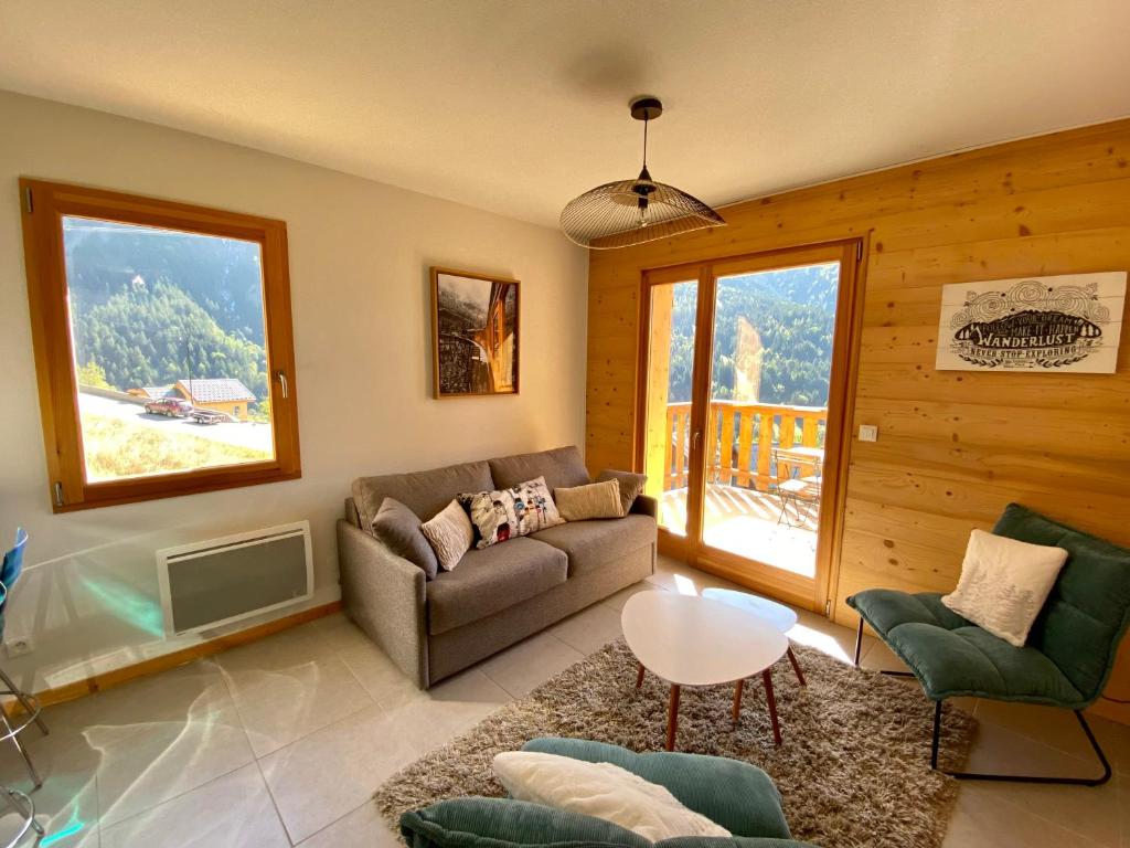 a living room with a couch and a table at Le Nid in Vaujany