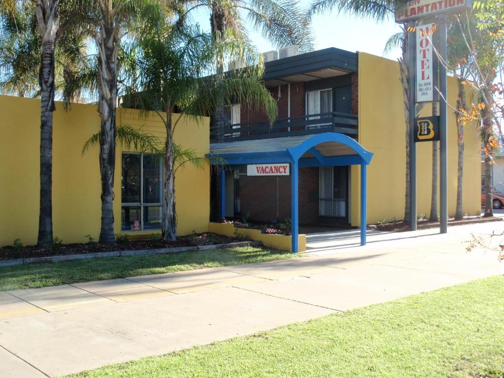 un edificio amarillo con un cartel que dice motel en Mid City Plantation Motel, en Mildura