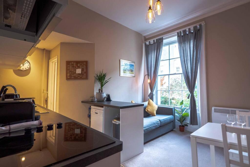 cocina y sala de estar con sofá y ventana en Great 1 Bed Walking Distance To Whiteladies Road, en Bristol