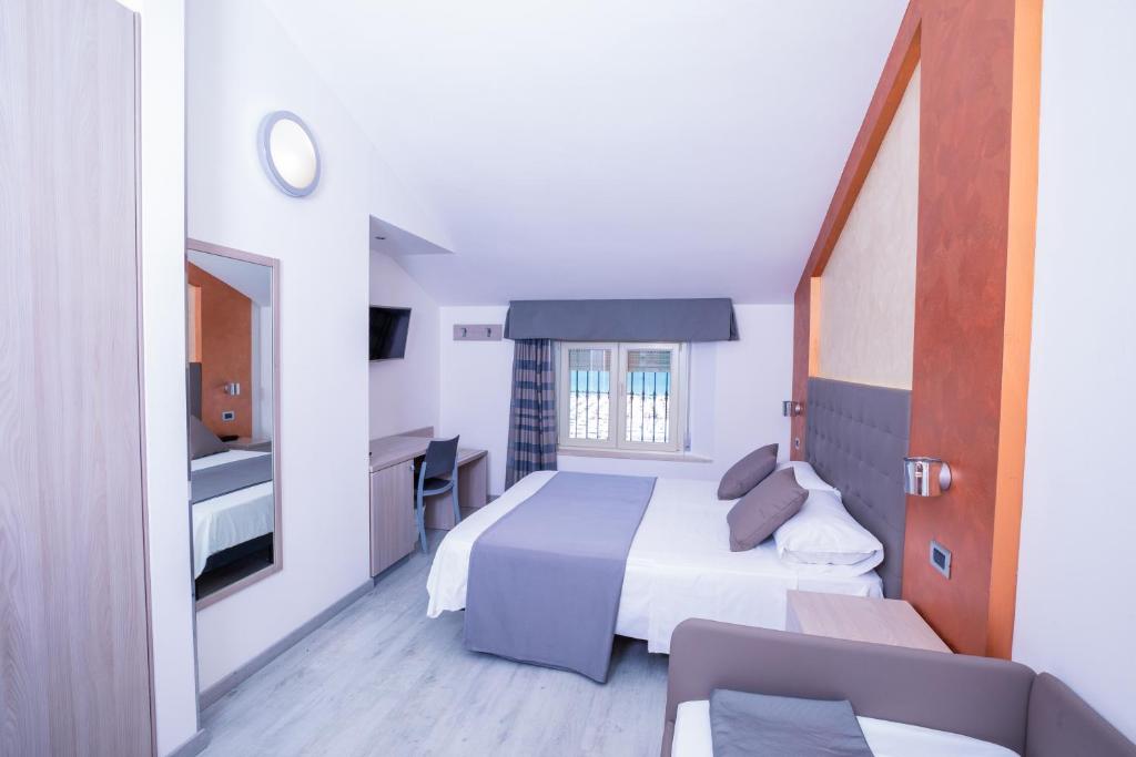 a hotel room with a bed and a window at Hotel Gabbiano in Rimini