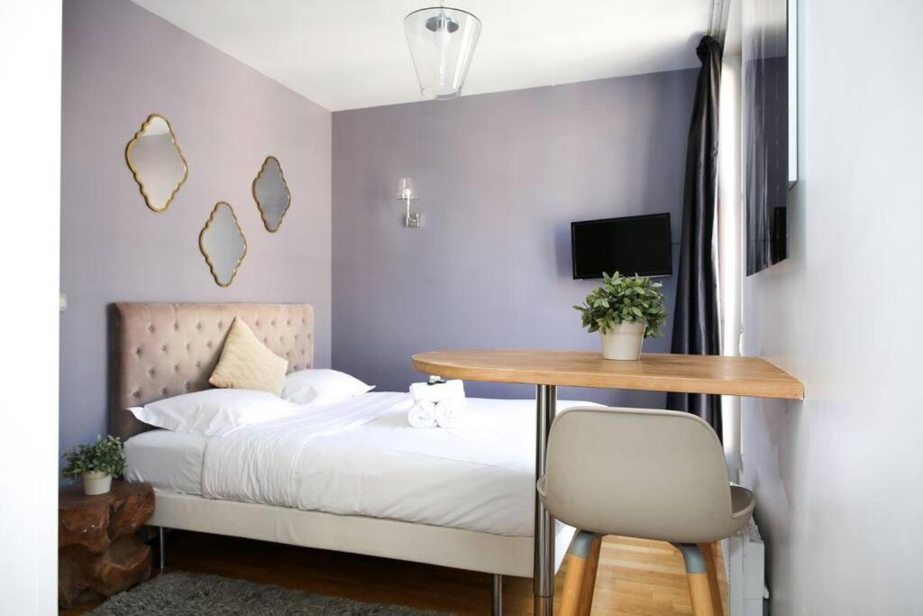 a bedroom with a bed and a table and a desk at 404 - Petit bijou dans immeuble hôtelier Paris 5 in Paris