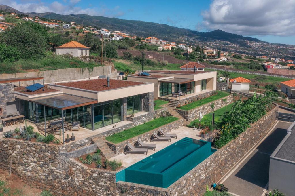 an aerial view of a house with a swimming pool at The Rock Villas in Estreito da Calheta