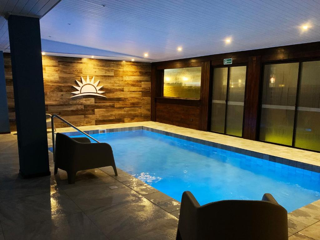 einen Pool in einem Haus mit beleuchtetem in der Unterkunft Hotel City Piriápolis in Piriápolis