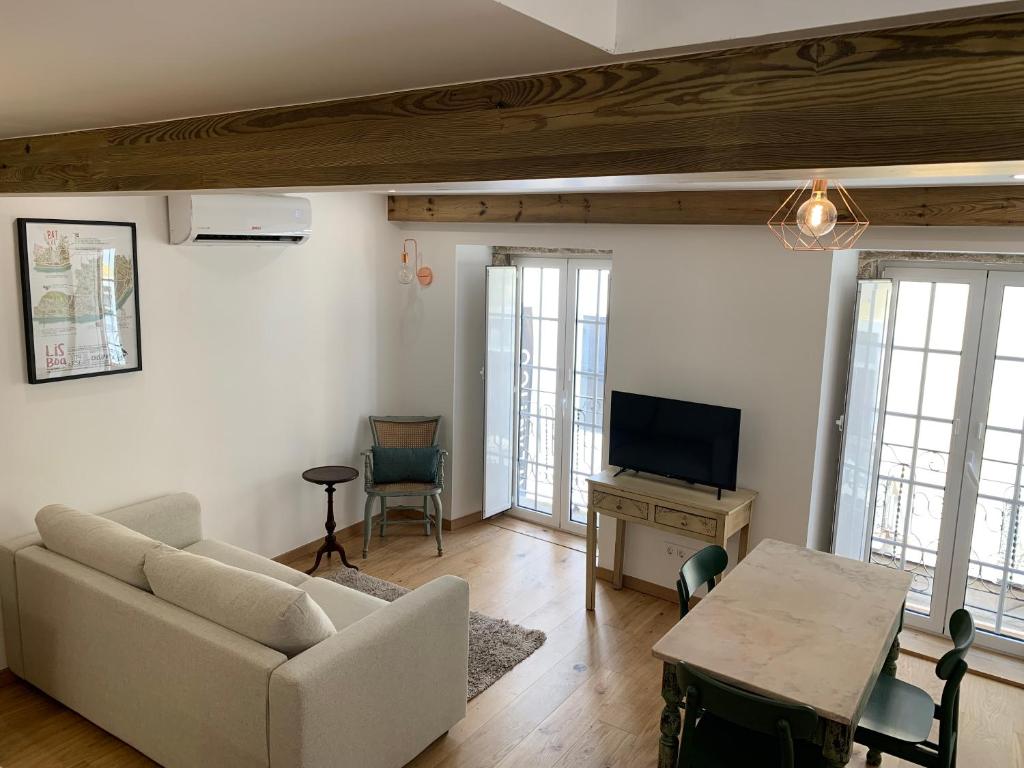 een woonkamer met een bank en een tv bij PS Lisbon Flats in Lissabon