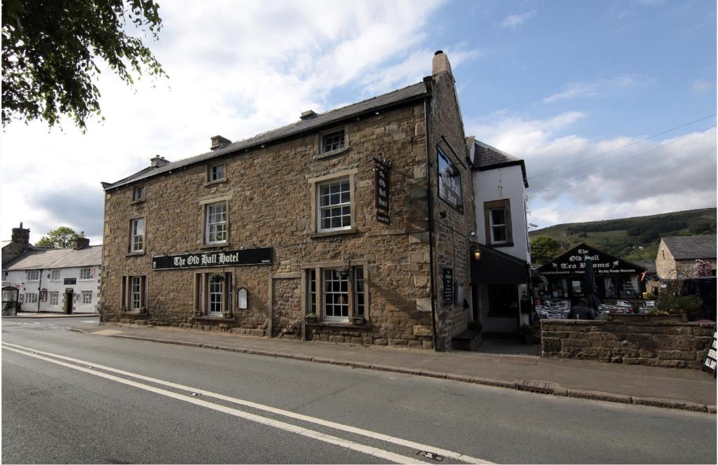 un antiguo edificio de piedra al lado de una calle en Old Hall Hotel Hope, en Hope