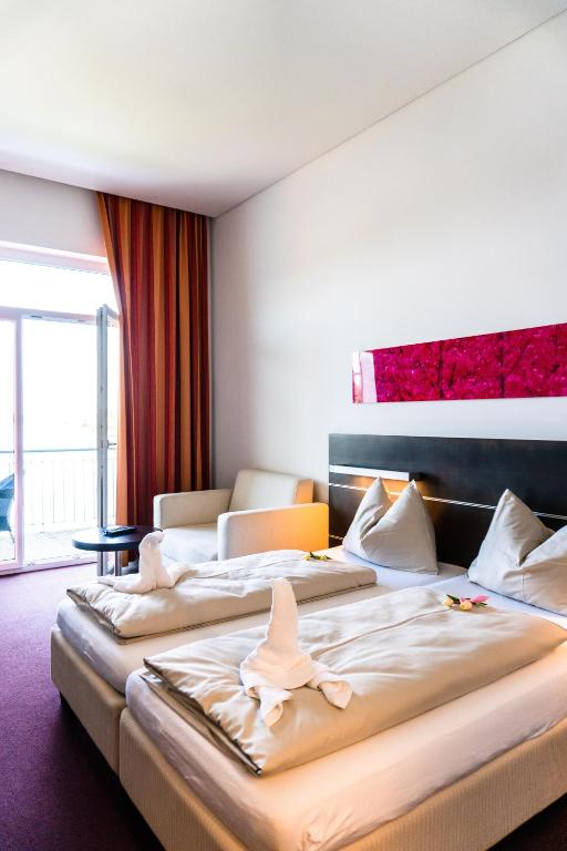 A bed or beds in a room at Neufeldersee Hotel & Restaurant
