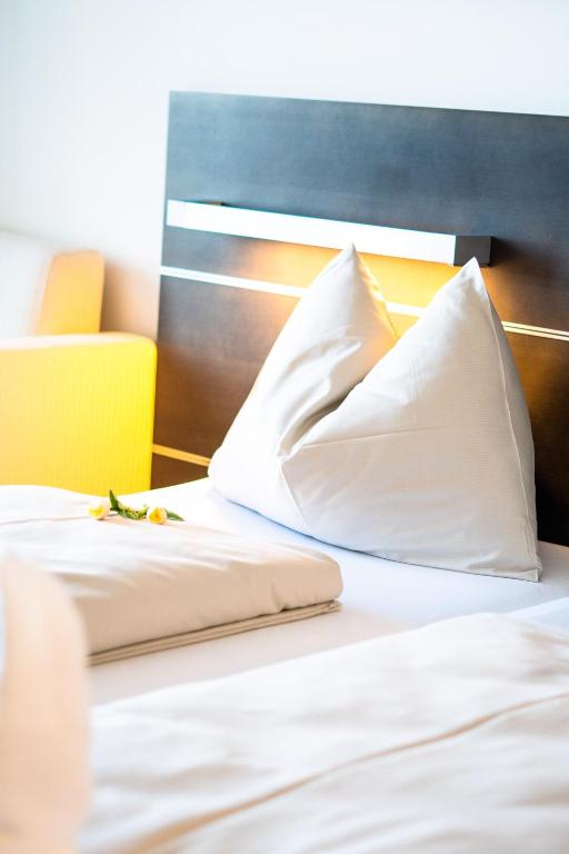 A bed or beds in a room at Neufeldersee Hotel & Restaurant