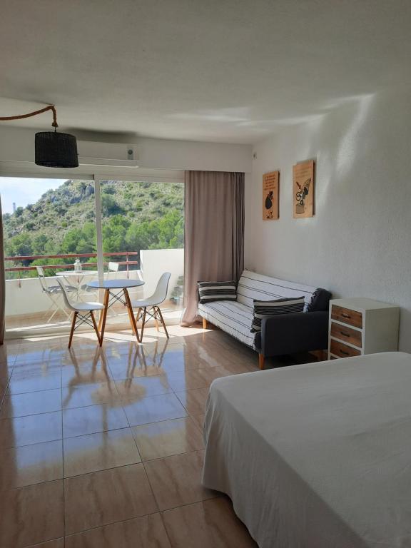 une chambre d'hôtel avec un lit, une table et des chaises dans l'établissement Cozy estudio "Edificio Siesta 2", à Alcúdia
