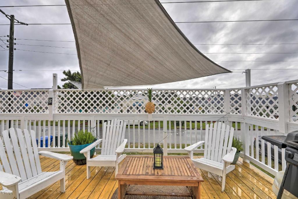 un patio con sillas blancas, una mesa y una botella de vino en Pet-Friendly Townhome, 2 Blocks to Atlantic Beach! en Atlantic Beach