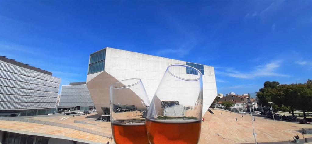 a glass of wine in front of a building at Boavista Class Inn in Porto