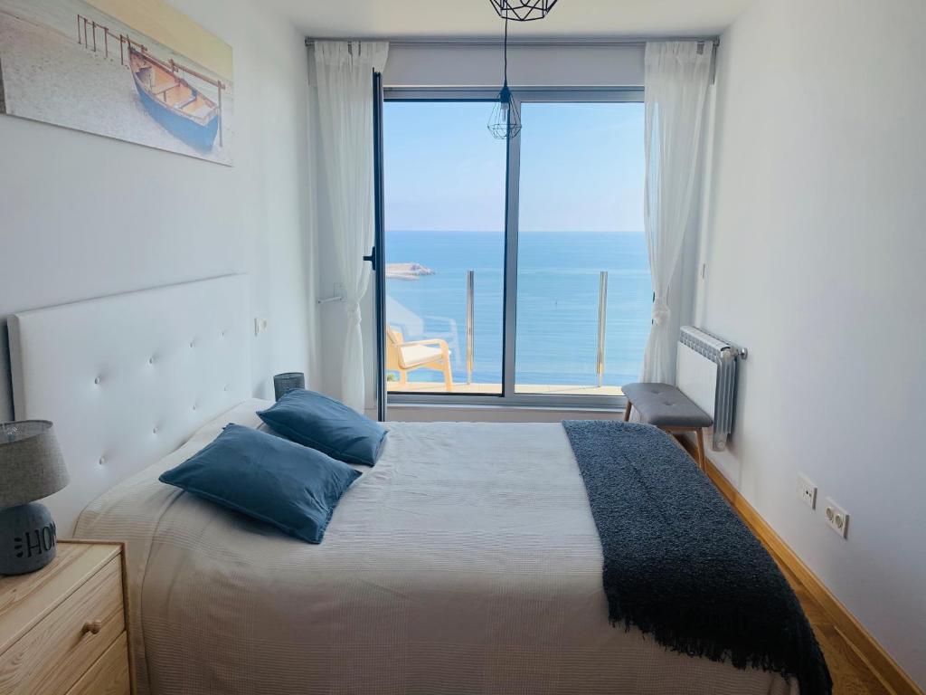 Schlafzimmer mit einem Bett und Meerblick in der Unterkunft Apartamentos la Marosa Delux in Burela