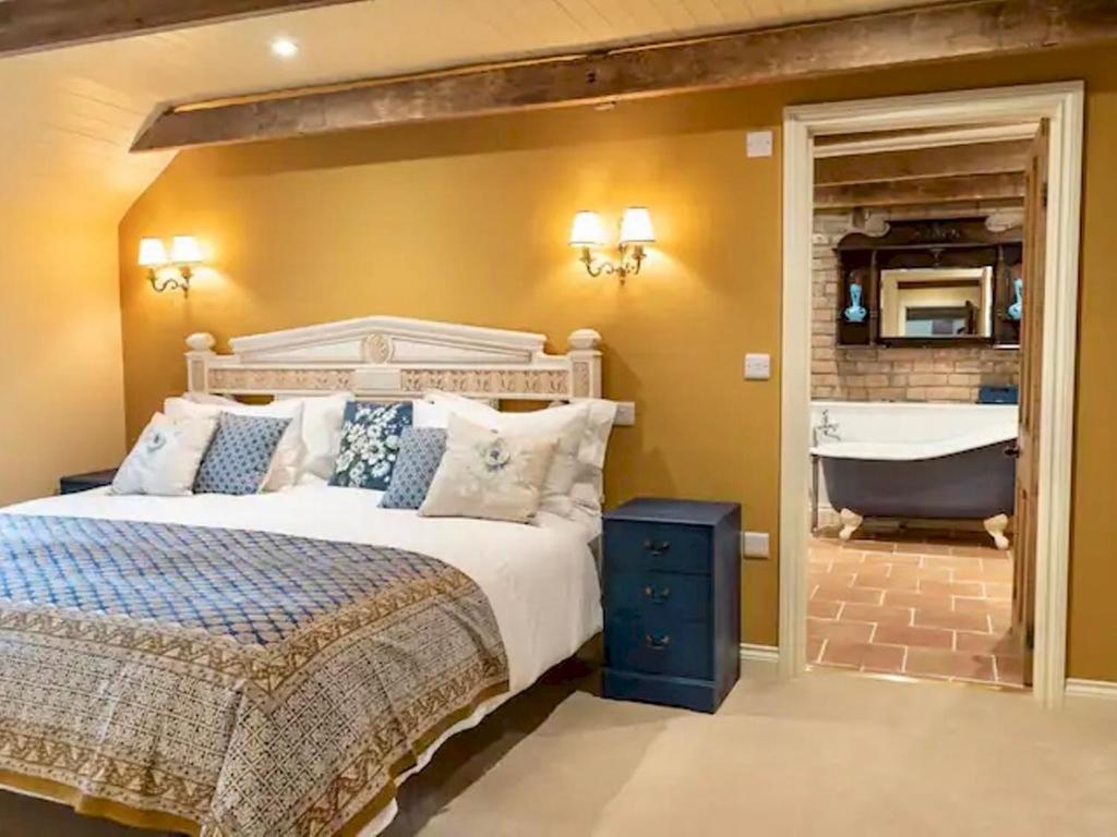 een slaapkamer met een bed en een bad bij Pass The Keys Goose Feather Barn, Wedmore luxury cottage for two in Wedmore