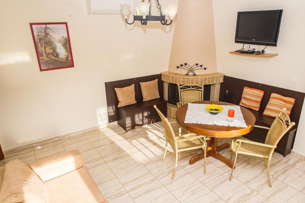 A television and/or entertainment centre at Cozy flats in an olive grove by the sandy beach
