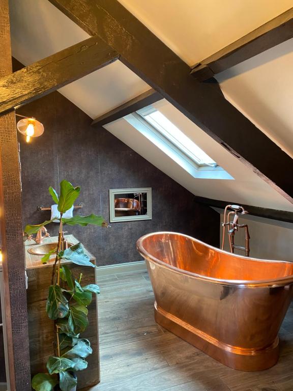 a large copper tub in a bathroom with a skylight at Newgate House in Morpeth