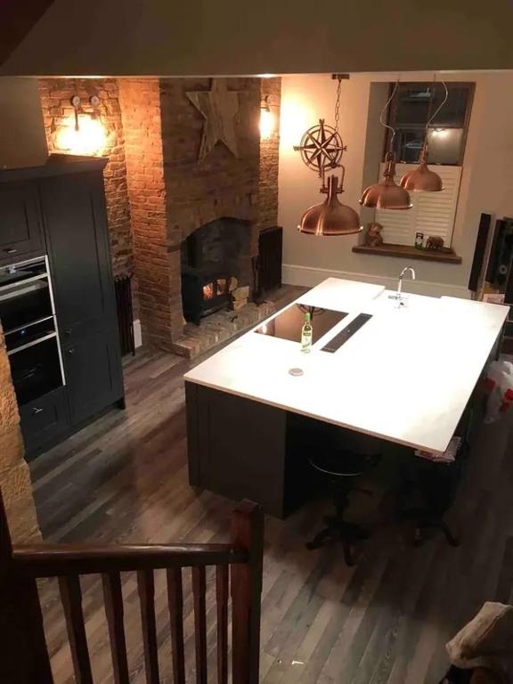a kitchen with a white counter and a fireplace at Newgate House in Morpeth